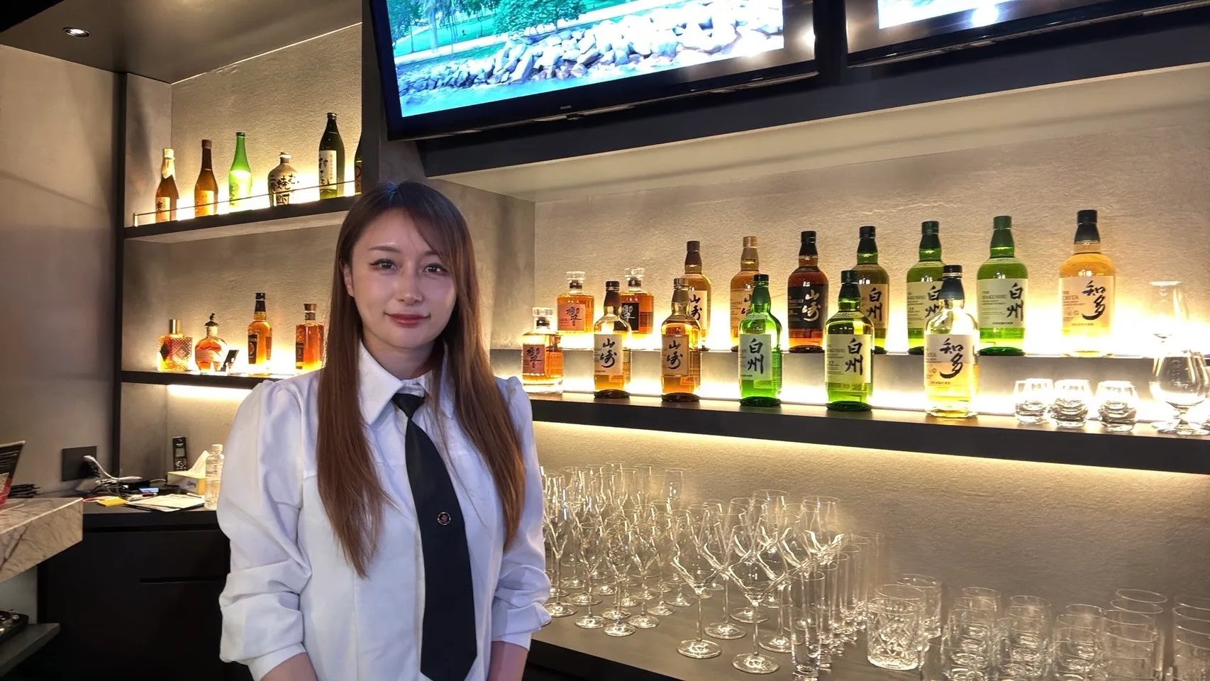 ボトル棚を背にしたえみママ